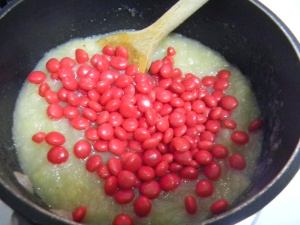 Mix the smashed apples, the jar of applesauce, and the entire package of red hots.  Simmer on low, stirring frequently, until all of the red hots are completely melted and incorporated.